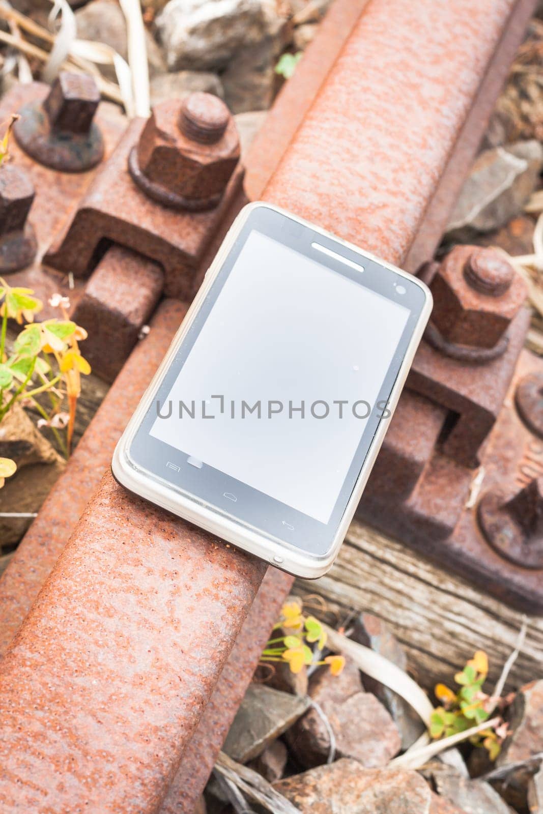 Travel on the tracks of the technology. Smartphone on rail like a metaphor.