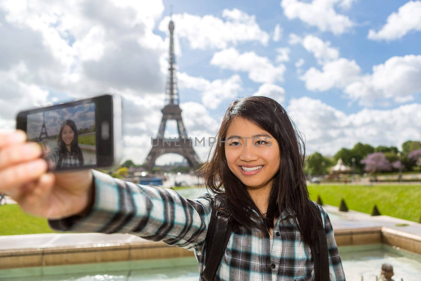 View of a Young attractive asian tourist in Paris taking selfie