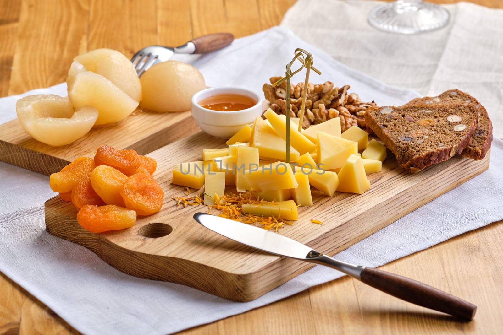 Set of various appetizers for wine - cheese, walnuts, dried apricots, honey and canned pear