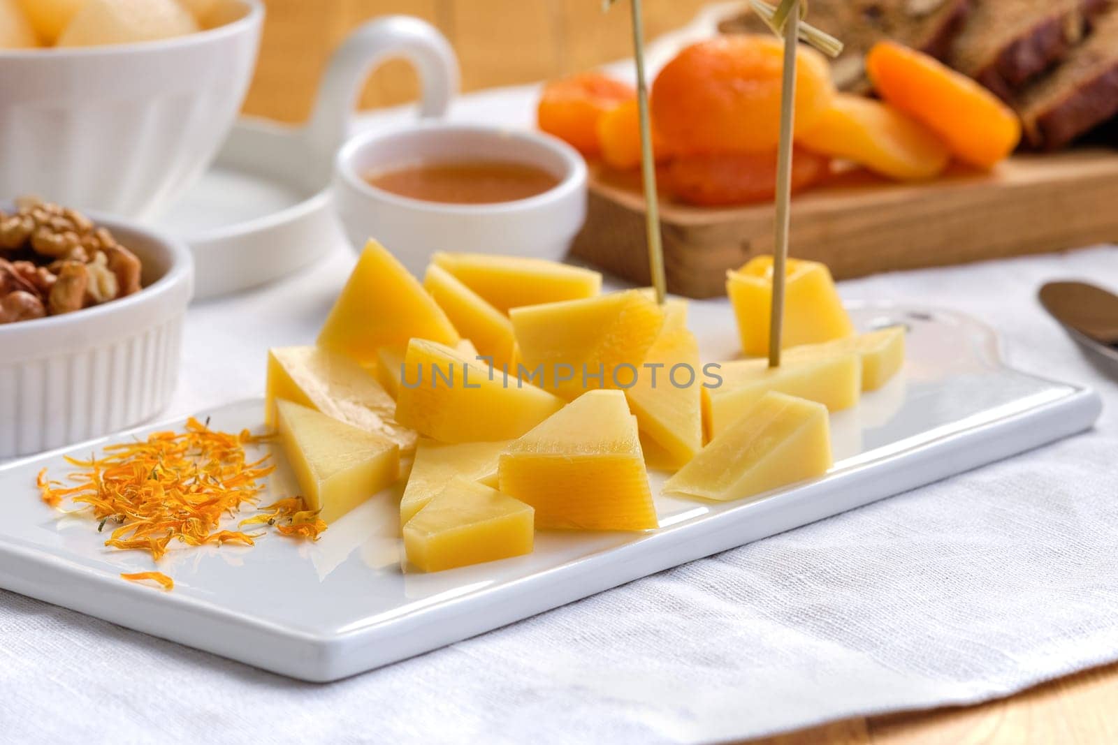 Set of various appetizers for wine - cheese, walnuts, dried apricots, honey and canned pear