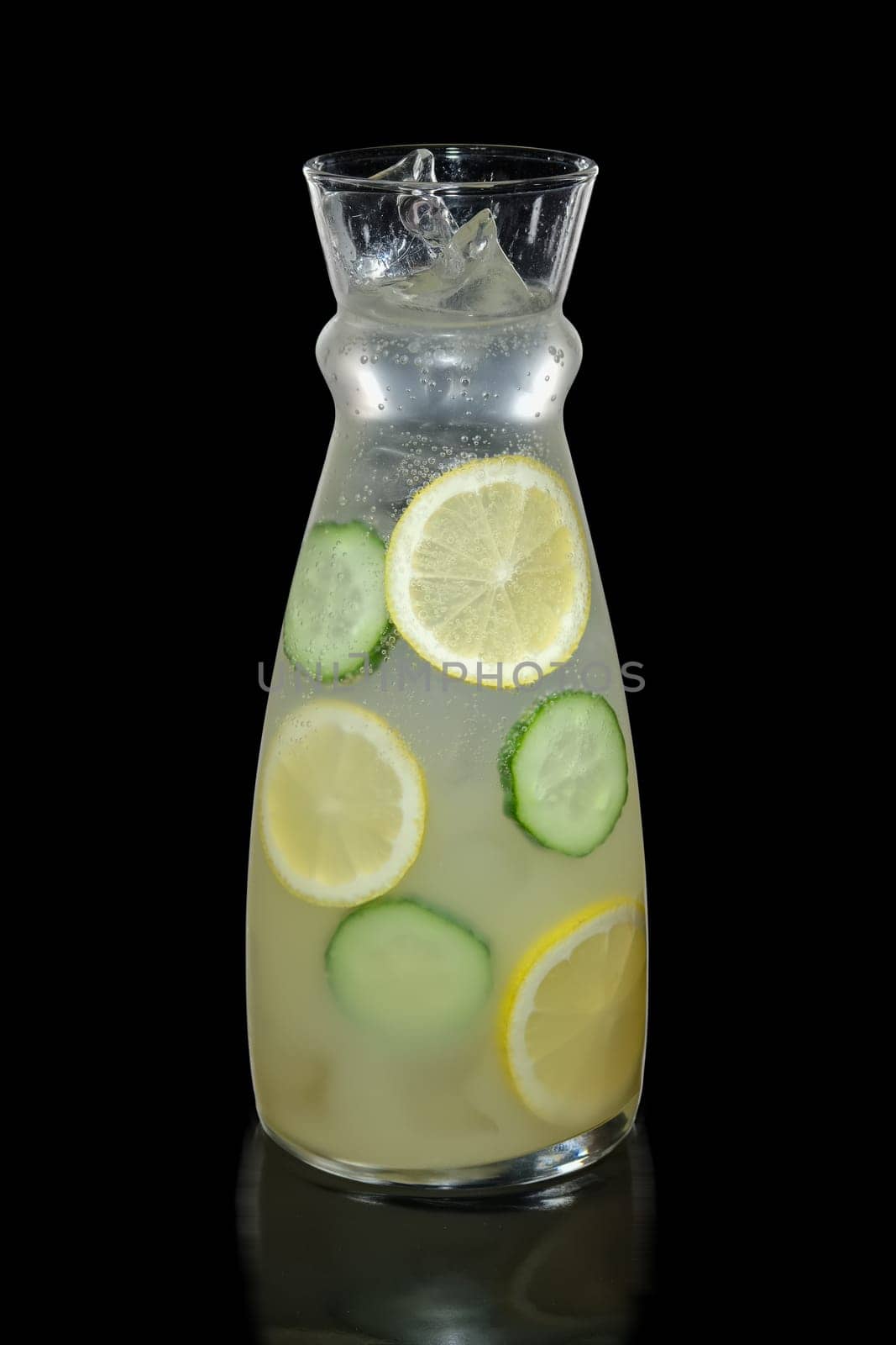 Decanter with lemon and cucumber lemonade isolated on black