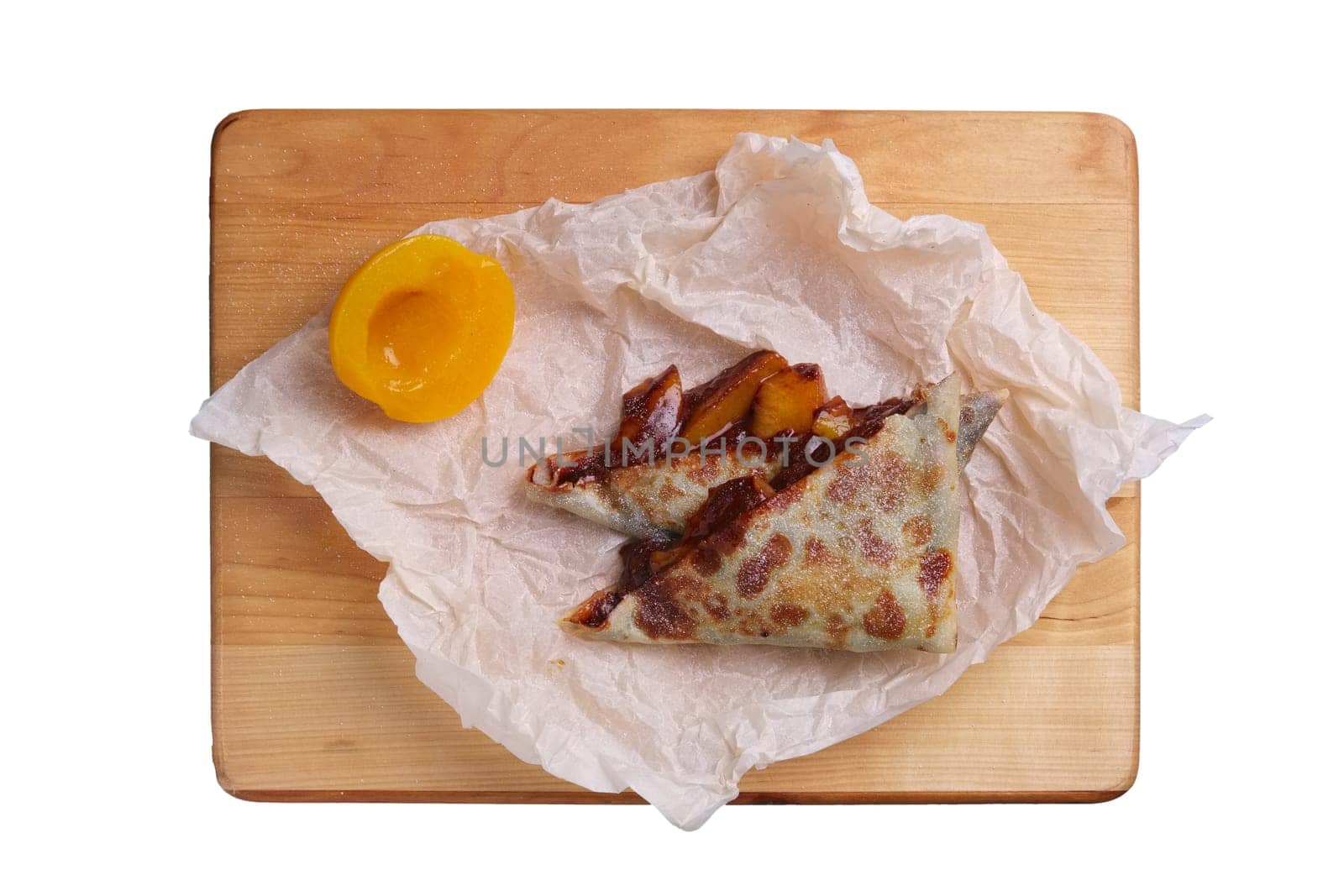 Thin pancakes stuffed with apricot and soft cheese isolated on white