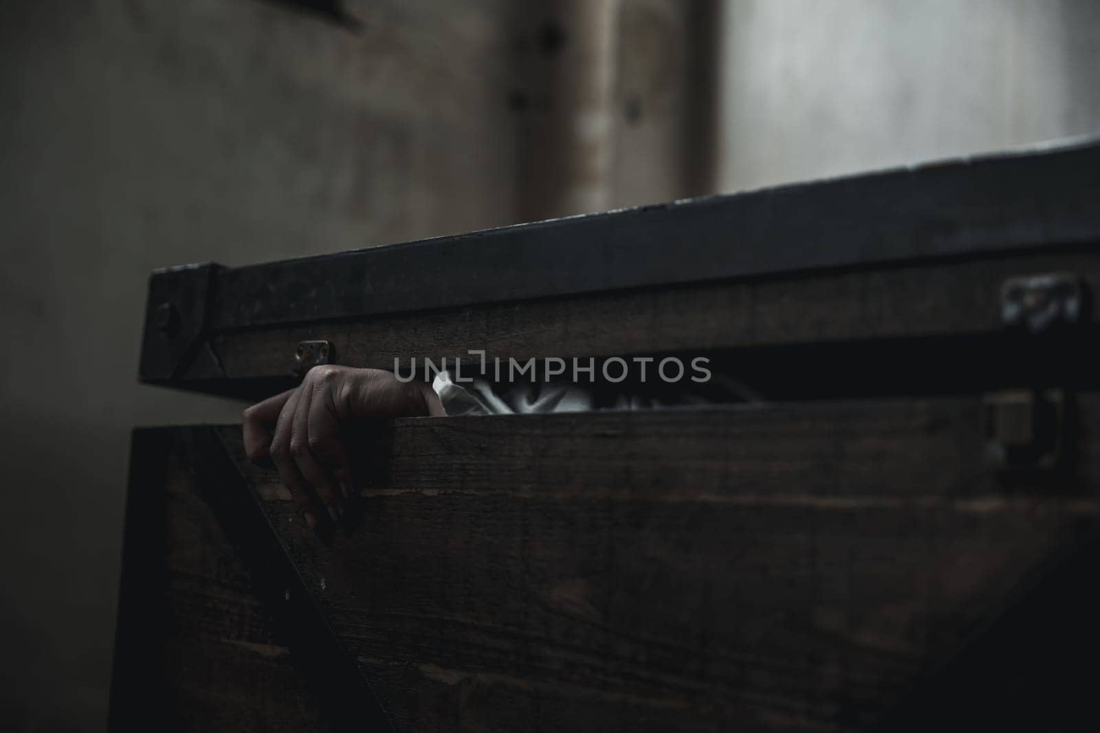 Horror ghost woman. Asian ghost horror creepy scary have hair covering face and eye lying in the old treasure chest, female makeup terror zombie face, murder, Closeup hand, Happy Halloween day concept