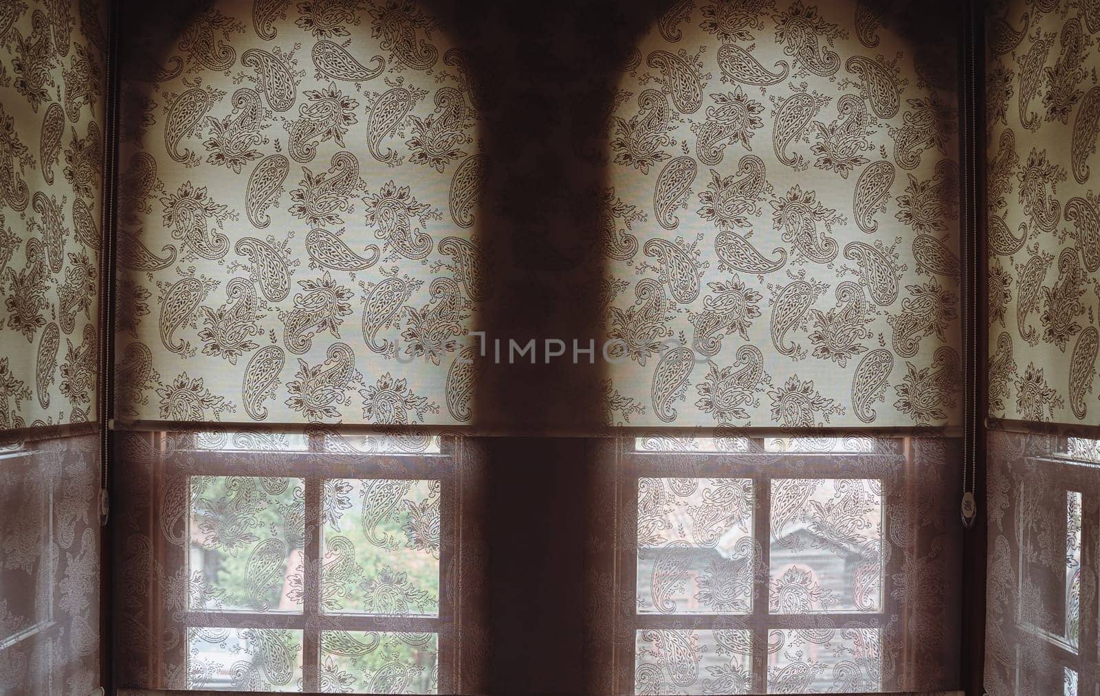 front view closeup of transparent fabric window blinds casting intimate light in a small room