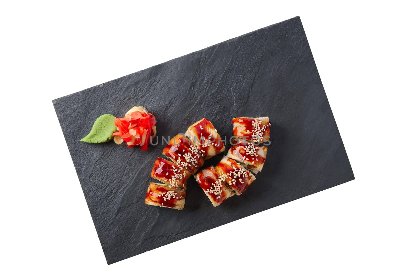 Portion of unagi roll with garnish isolated on white