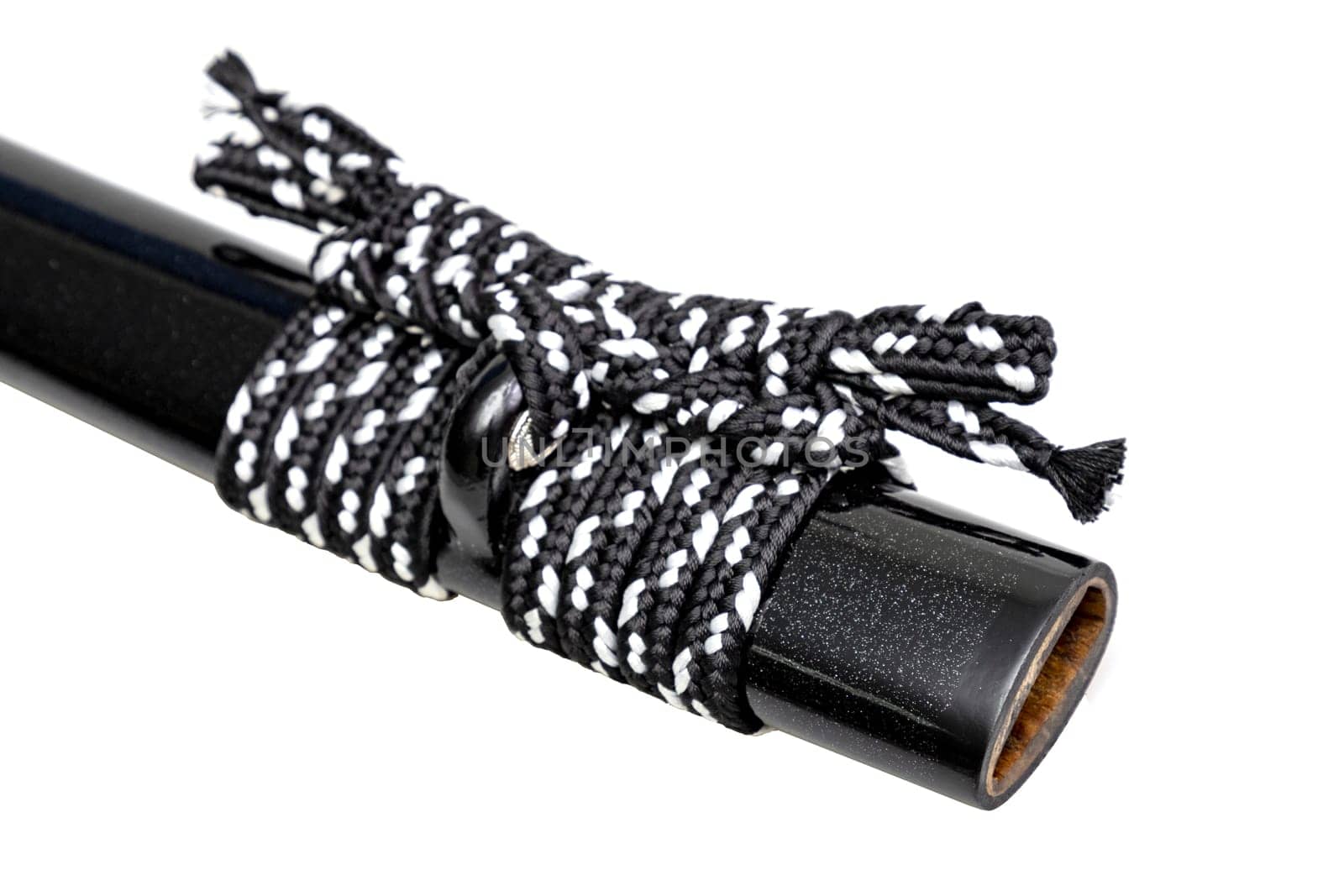 Close up shot of Sageo - Thick black-white silk rope for tying the scabbard of Japanese swords. It was a rope for the samurai to tie at the waist. isolated on white background. Selective focus.
