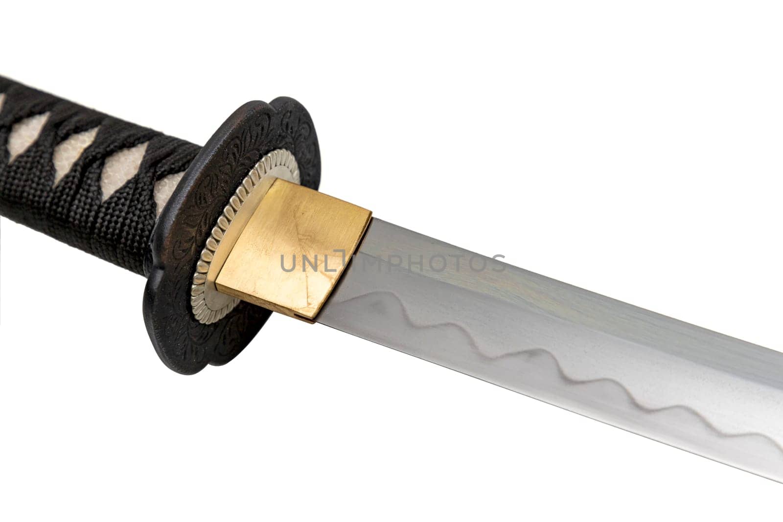 The Habaki - collar is made of polished brass. It is at the base of a Japanese sword blade with a wavy pattern on the sharp part. isolated on a white background. Selective focus.