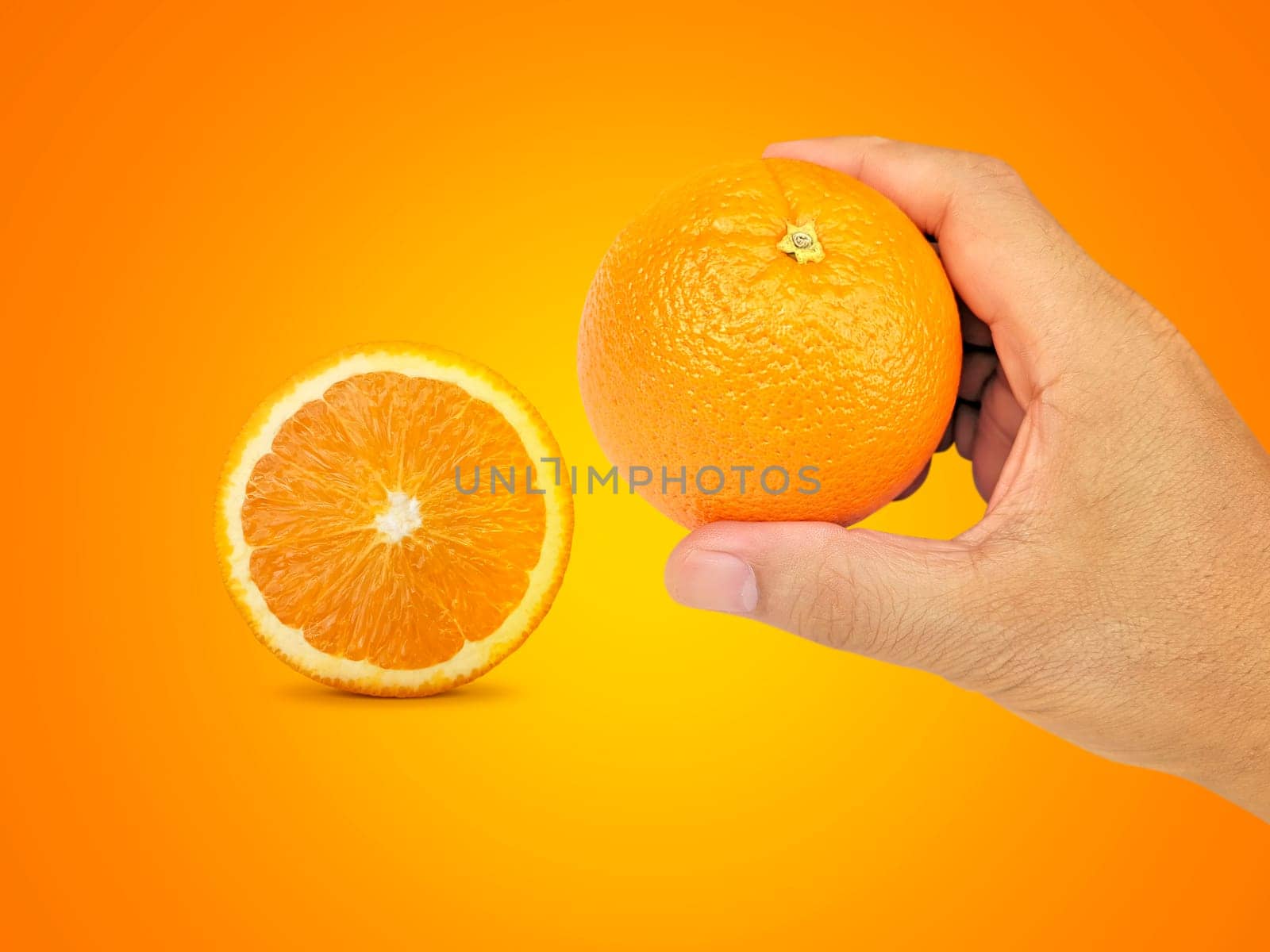 hand holding orange fruit and orange slices on orange background