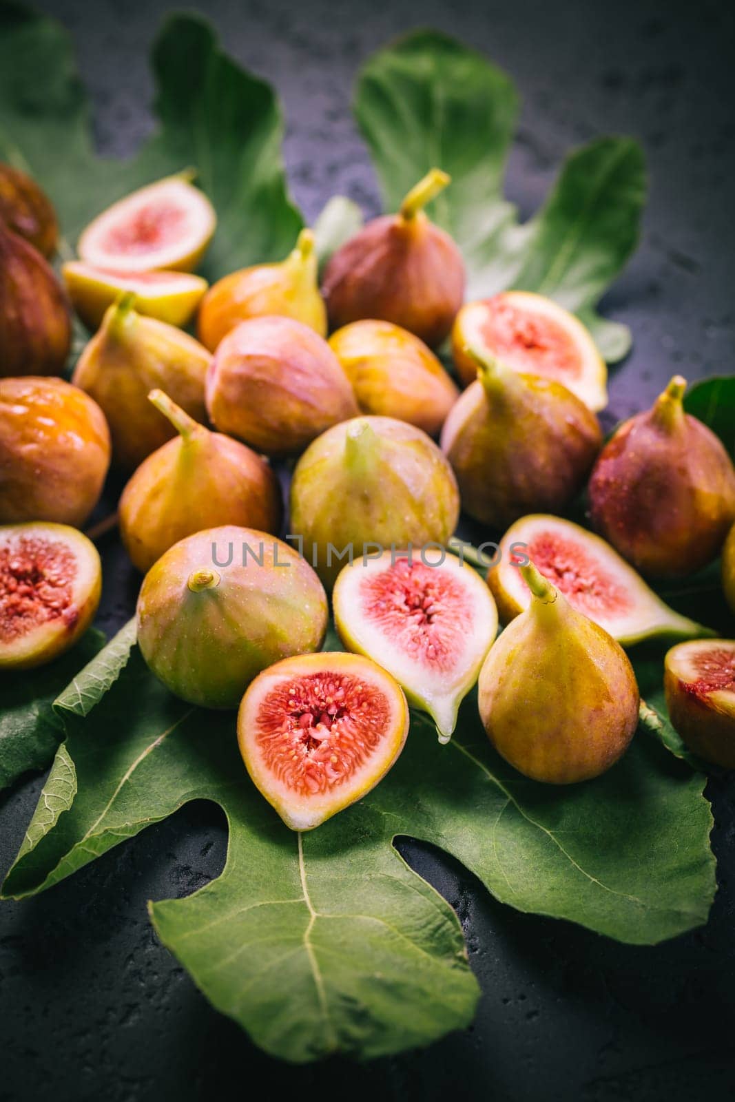 Harvesting - tasty organic figs on black background