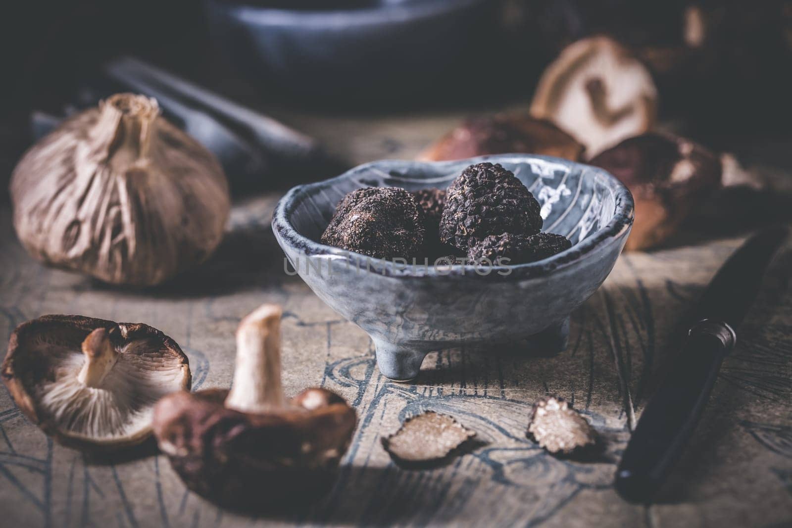Truffles and shiitake mushrooms and spices on kitchen table