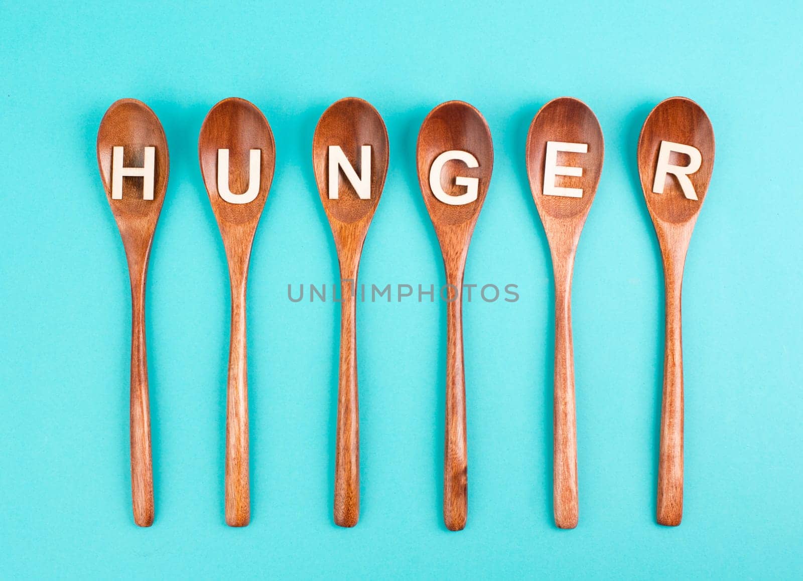 Hungry is standing in german language on the wooden spoons, food shortage and starving because of the war and inflation, political issue