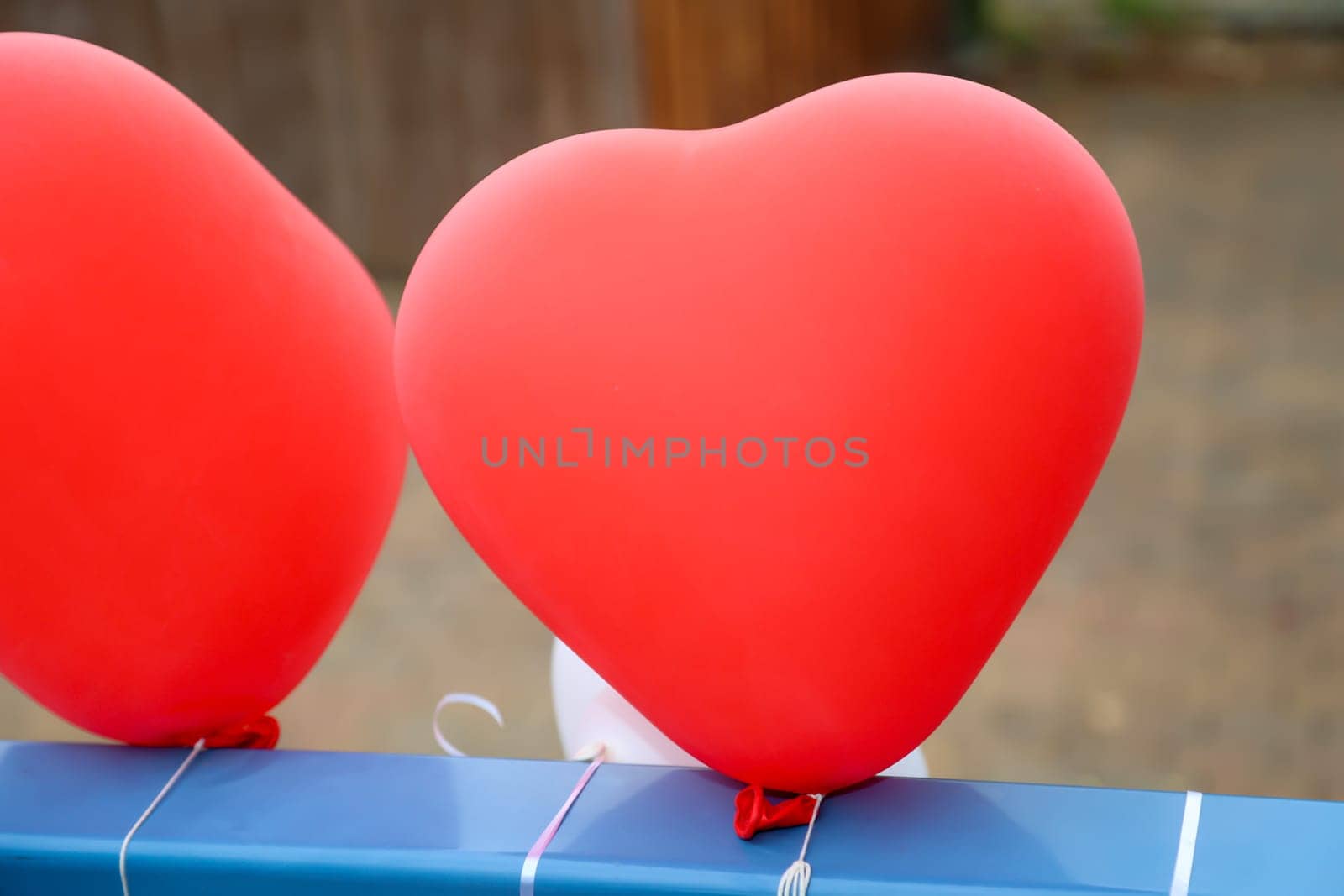 Balloons in the shape of a heart attached to a railing for decoration at a wedding.
