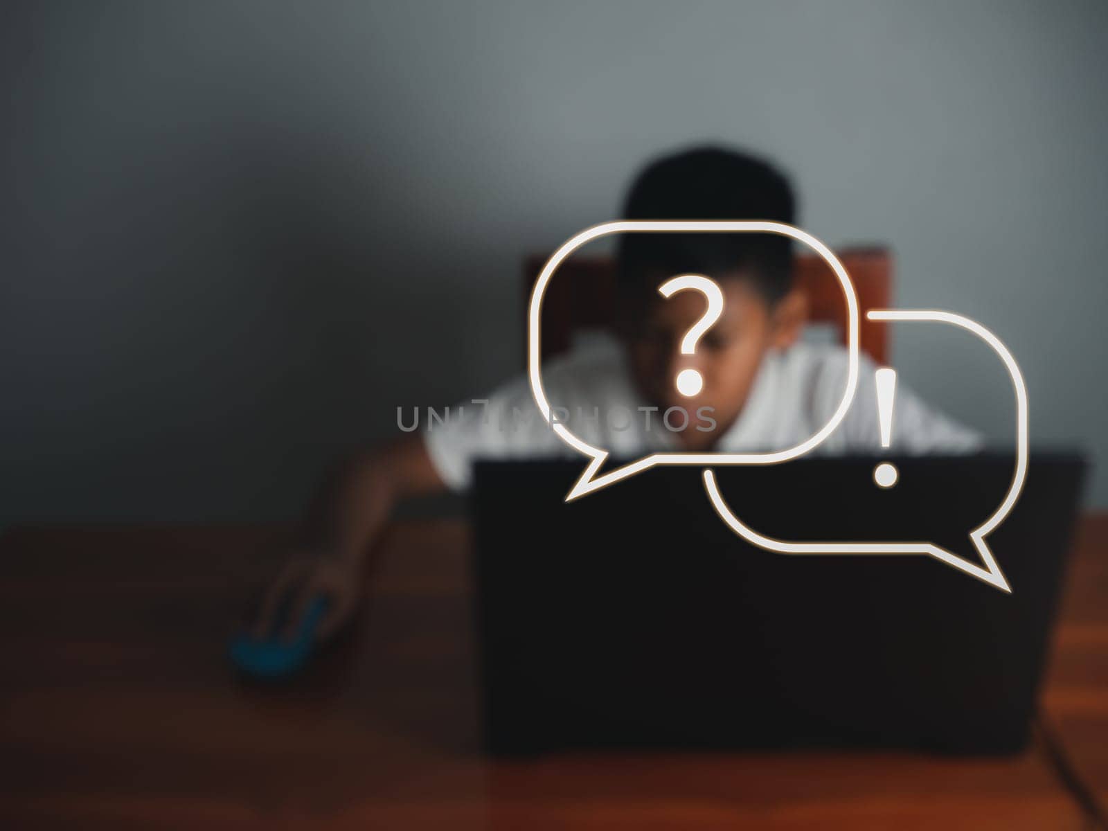 blurry pictures of boy sits staring at the laptop and his hand is holding the mouse with icon about learning on the front. educational concept, educational information search, copy space