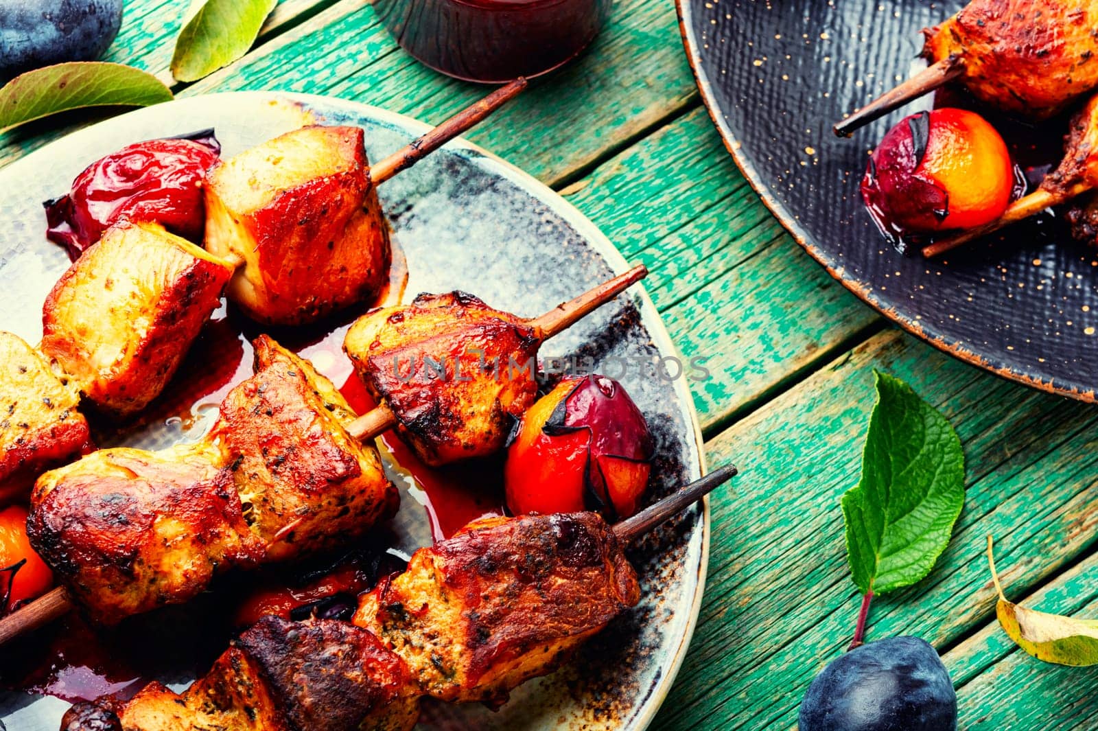 Fried meat grilled on wooden skewers.Kebabs in plum sauce.BBQ meat