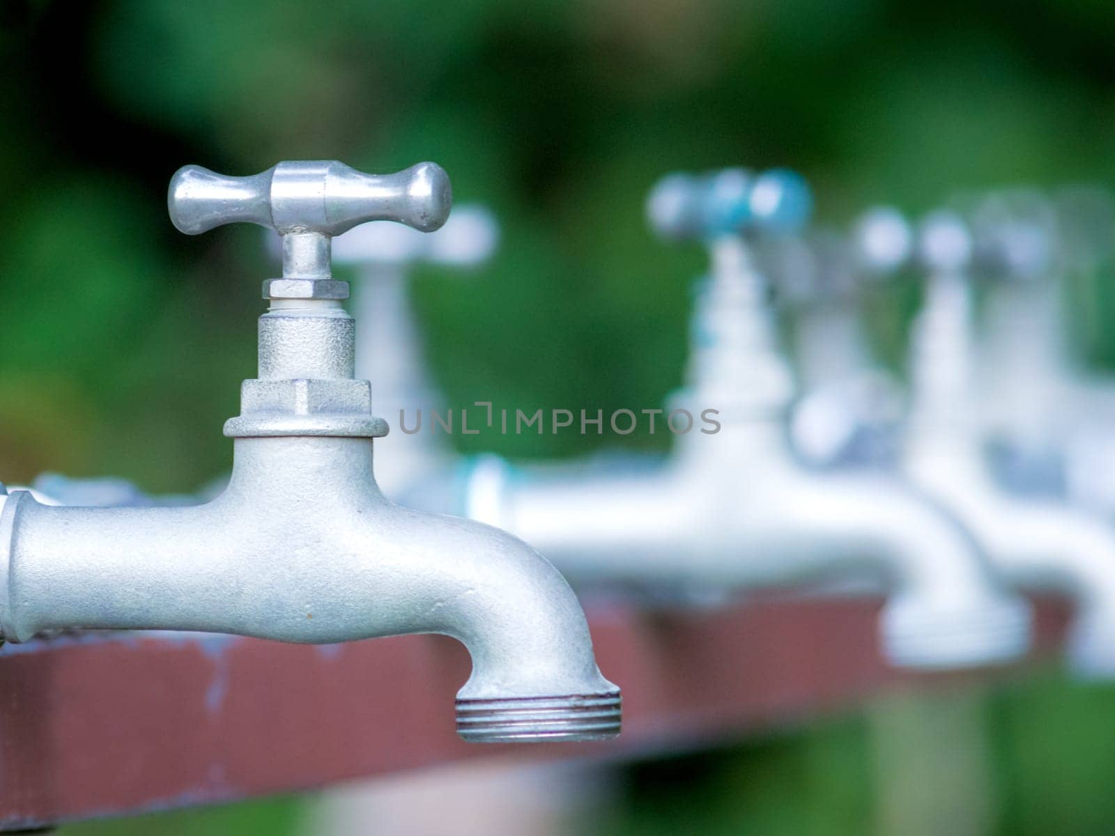 Brass water tap in nature background.