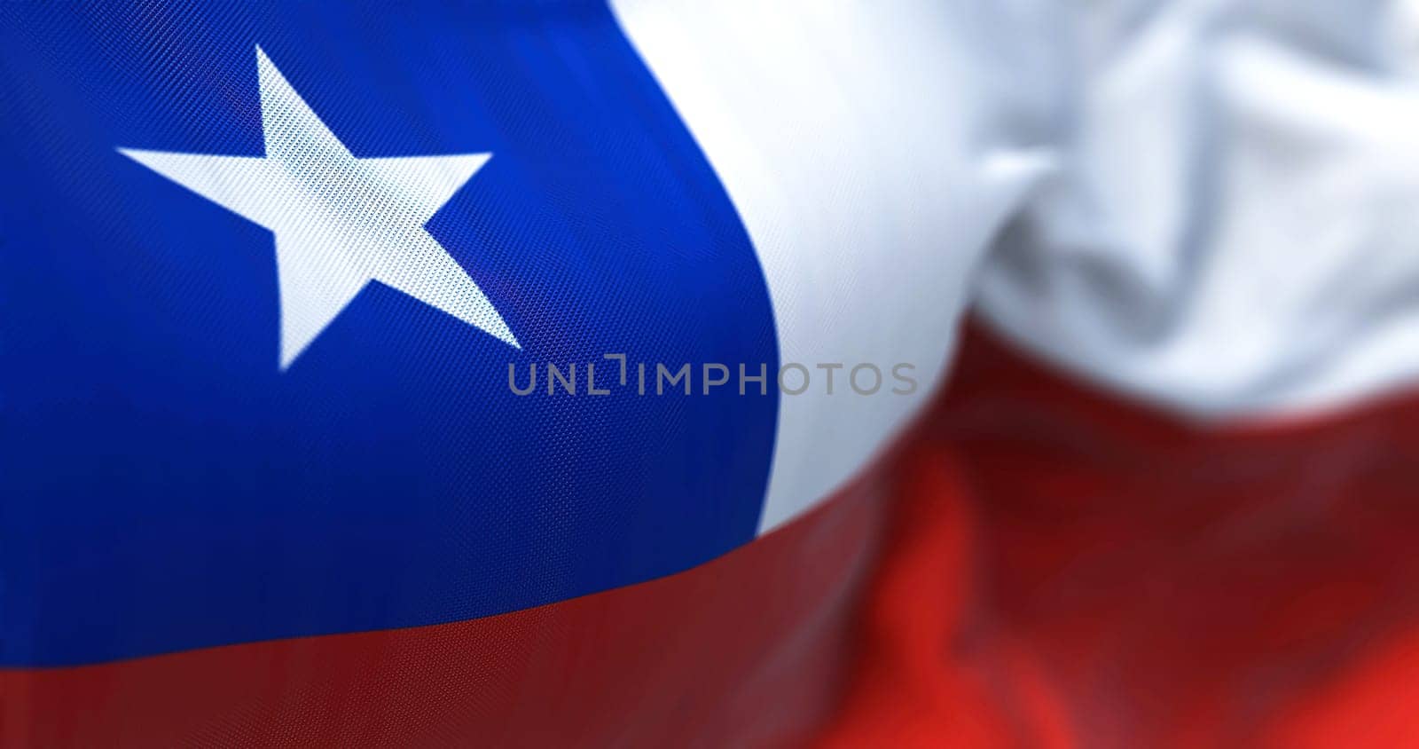 Close-up view of the Chile national flag waving in the wind. The Republic of Chile is a country in the western part of South America. Fabric textured background. Selective focus
