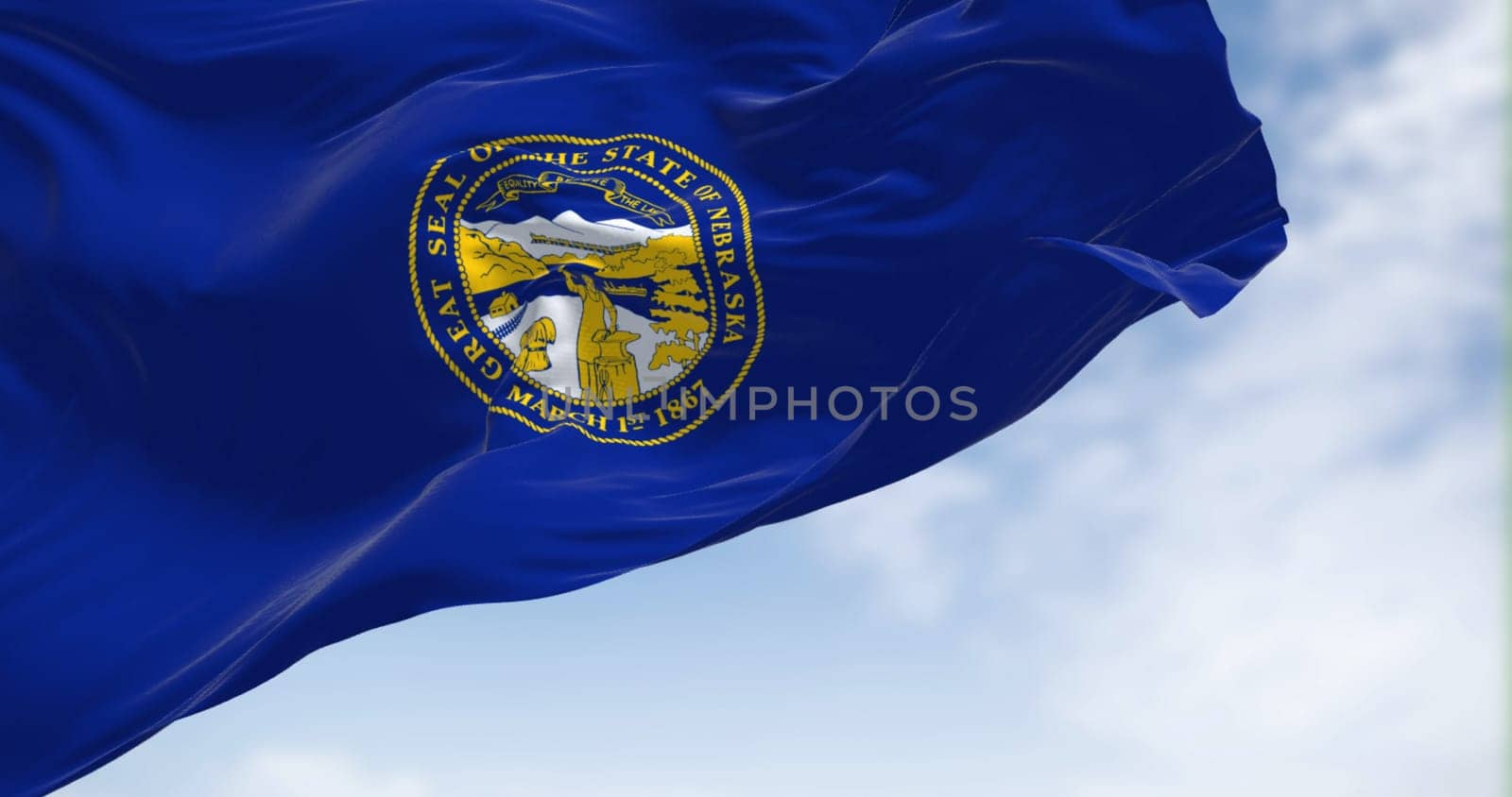 The Nebraska state flag waving in the wind. Nebraska is a state in the Midwestern region of the United States.