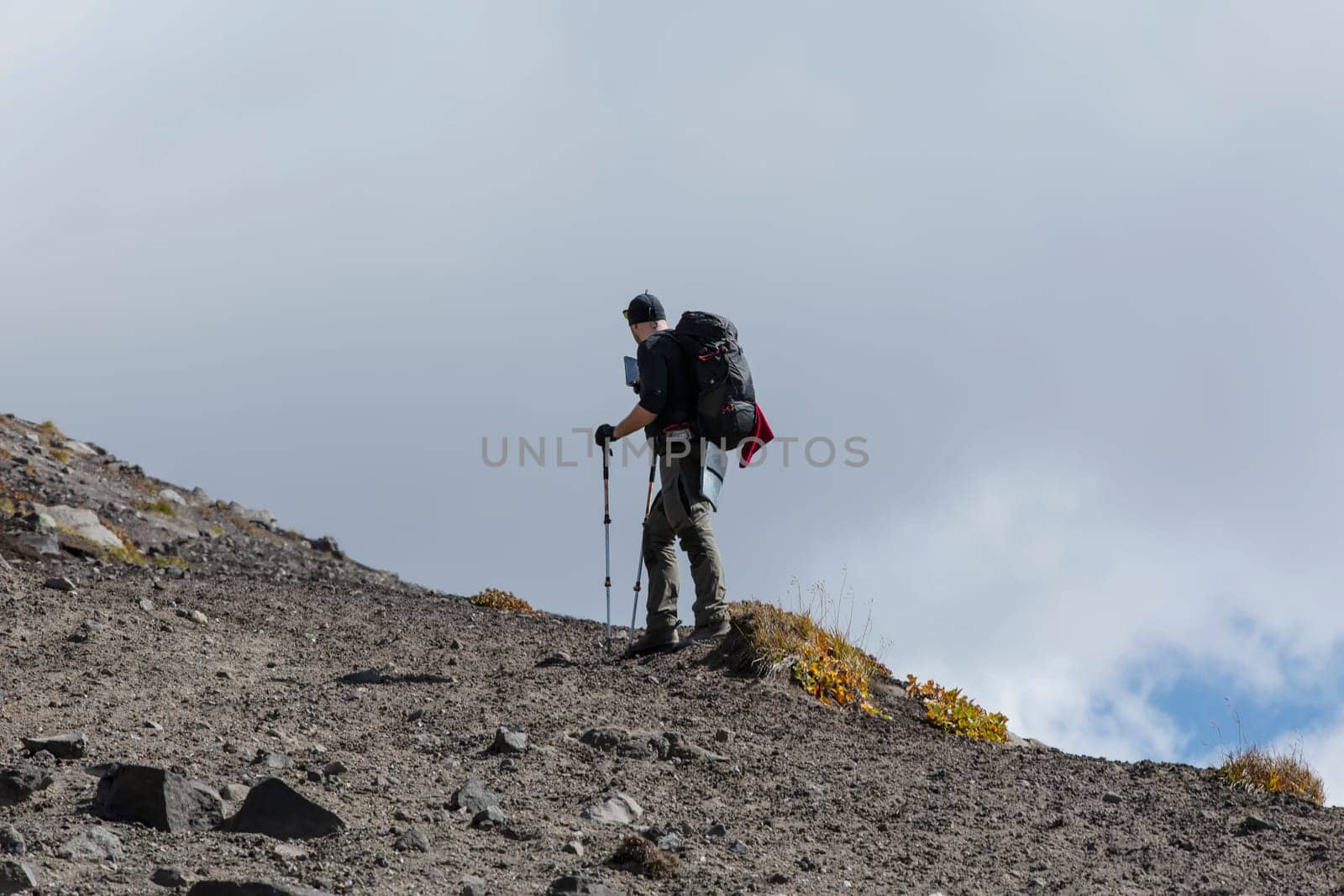 The backpacker on the volcano and mountain on Kamchtka peninsula