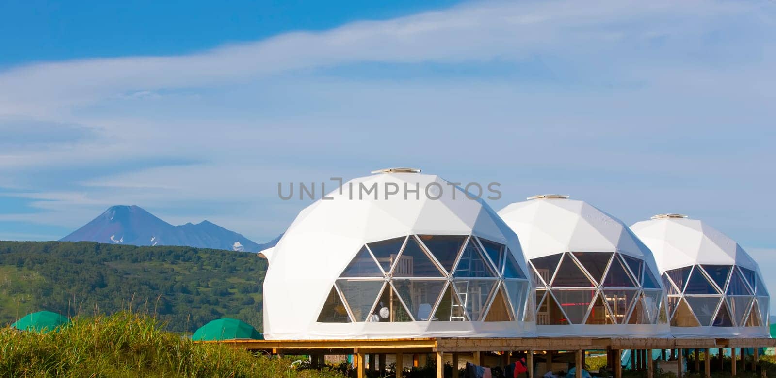 The Glamping house  and volcano, rural landscape, tent houses in Kamchatka peninsula. Selective focus.