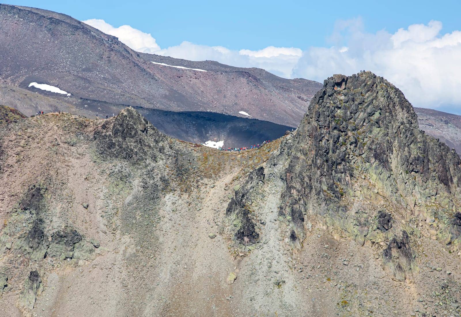 The tourists on a camel extrusion on the Kamchatka peninsula near Avachinsky and Koryaksky volcano