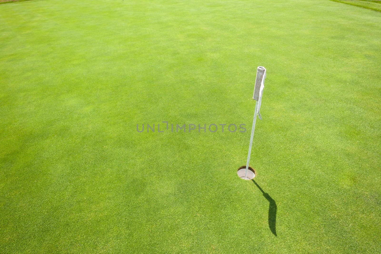 Golf practice putting green with flagstick hole