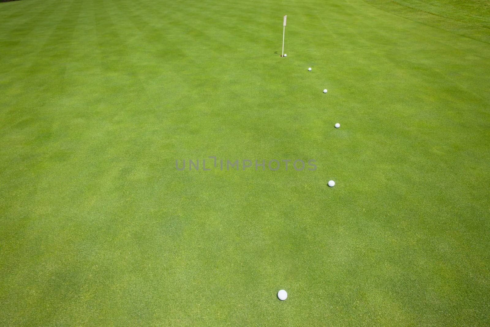 Golf putting green with balls on predicted line to hole