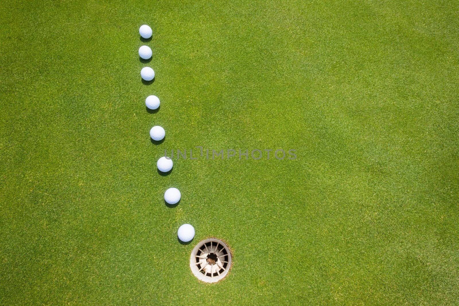 Golf putting green with balls on predicted line to hole