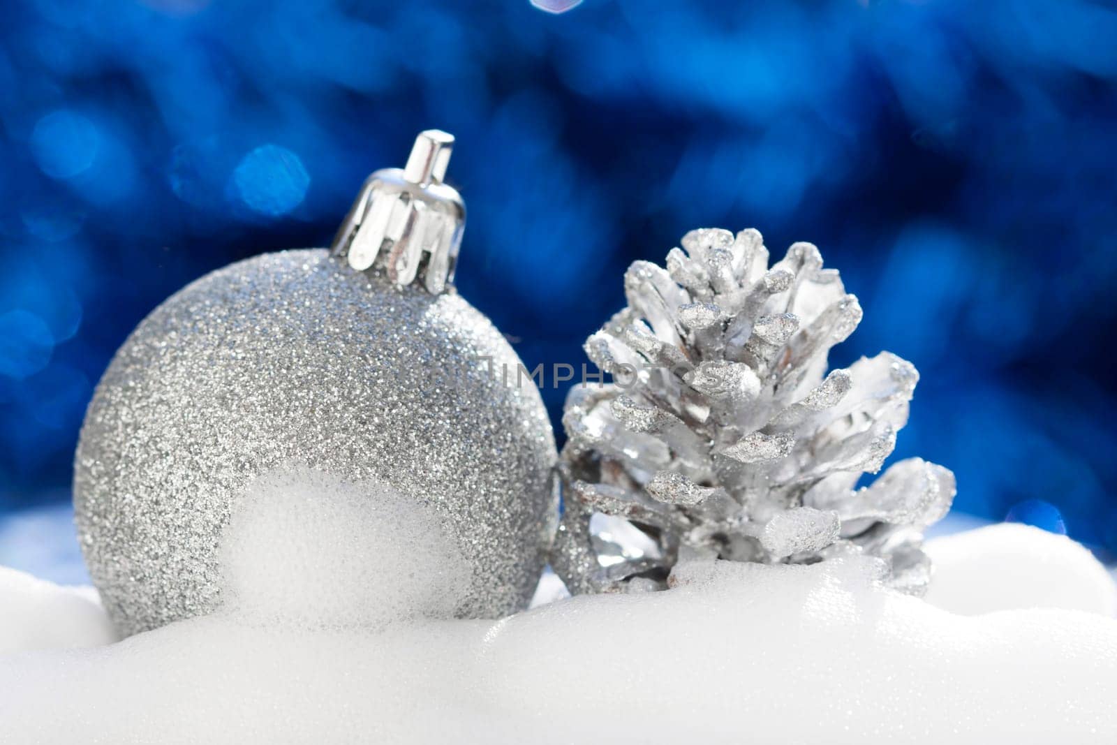 Silver christmas decoration with ball and cone on blue background