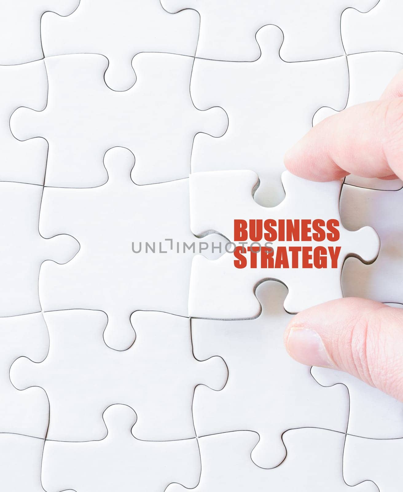 Missing jigsaw puzzle piece with word BUSINESS STRATEGY. Business concept image for completing the puzzle.