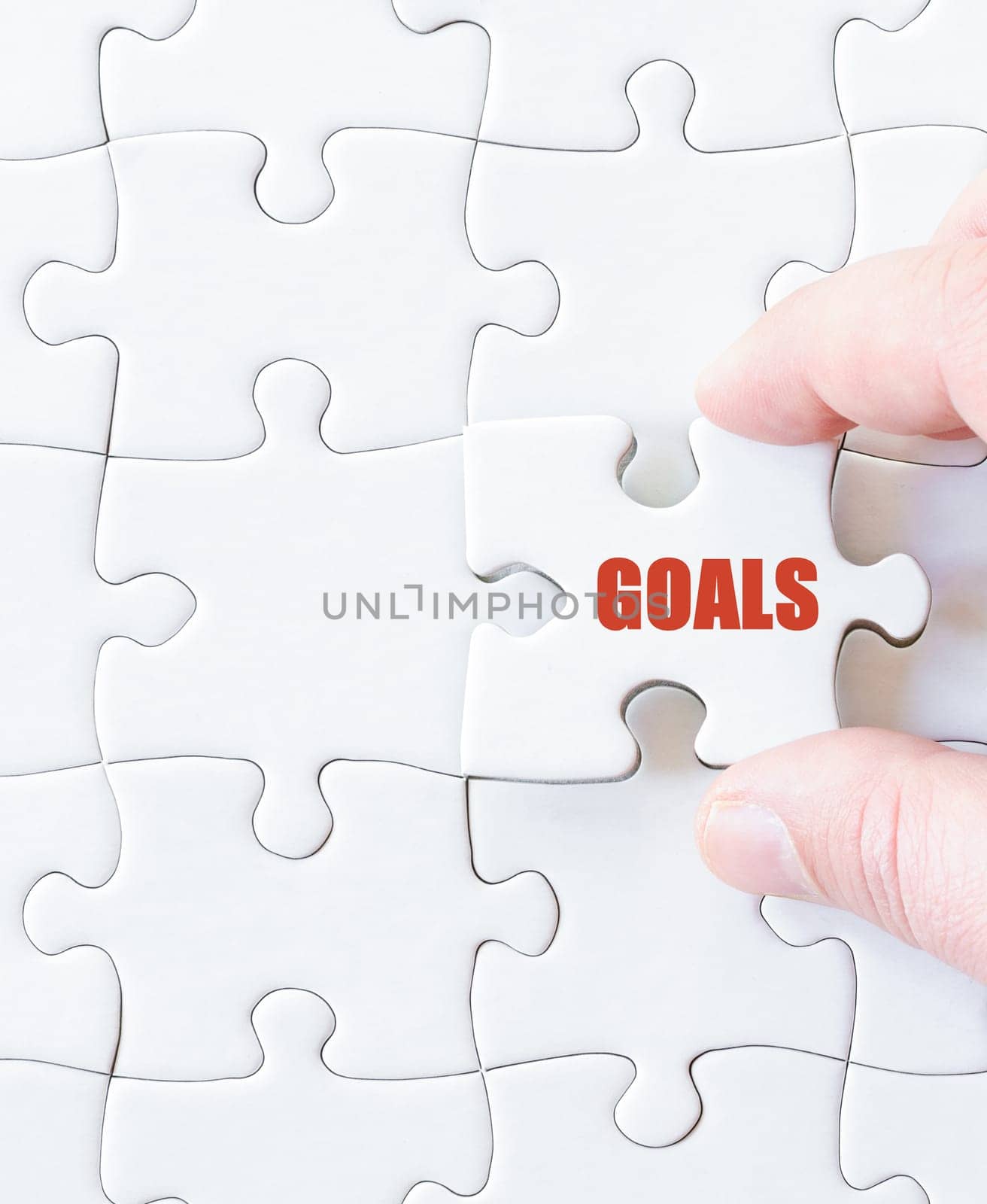 Missing jigsaw puzzle piece with word GOALS. Business concept image for completing the puzzle.