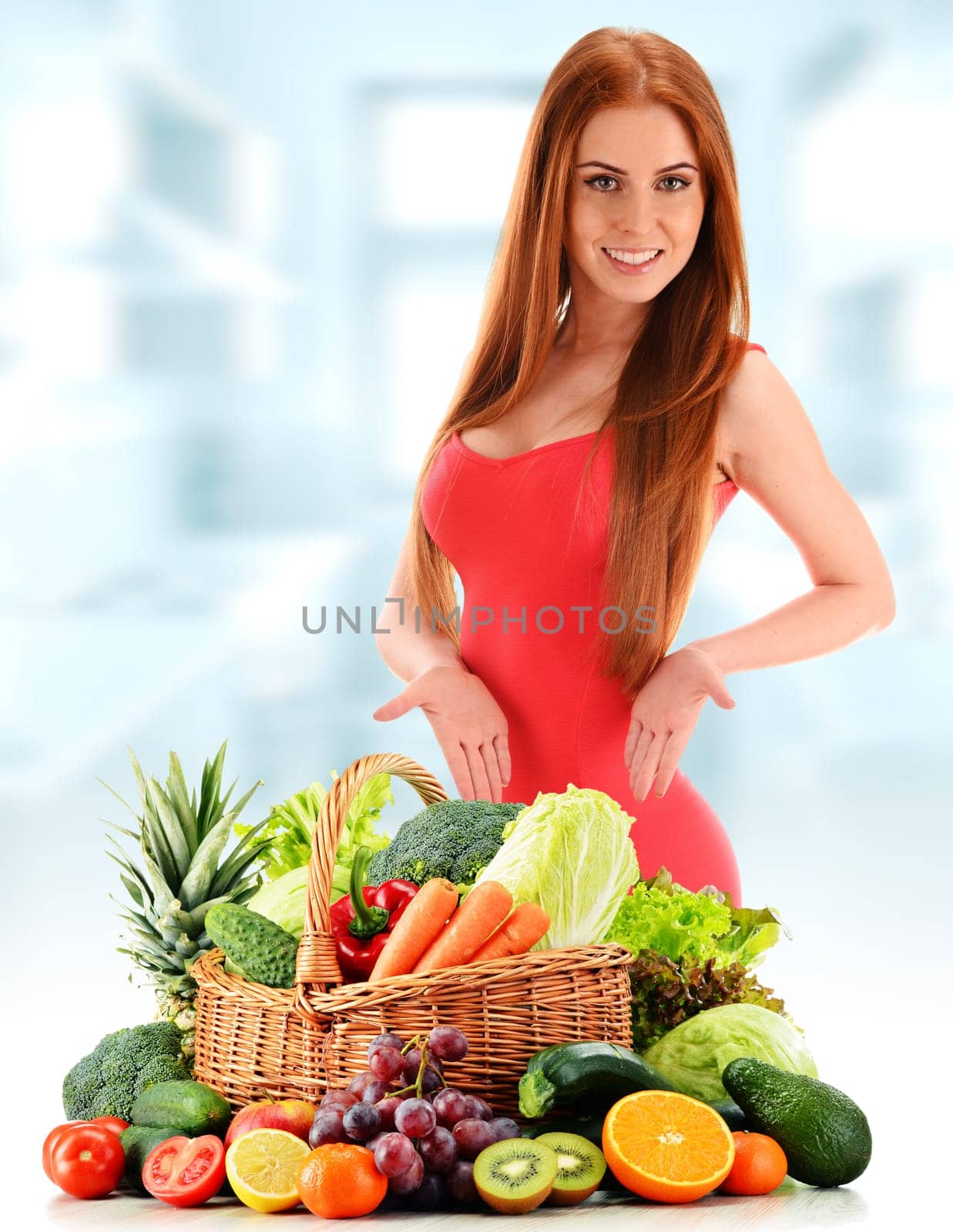 Young woman with variety of organic vegetables and fruits.