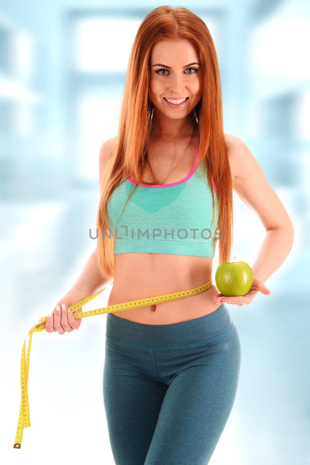 Young woman holding measure tape and apple. Weight loss.
