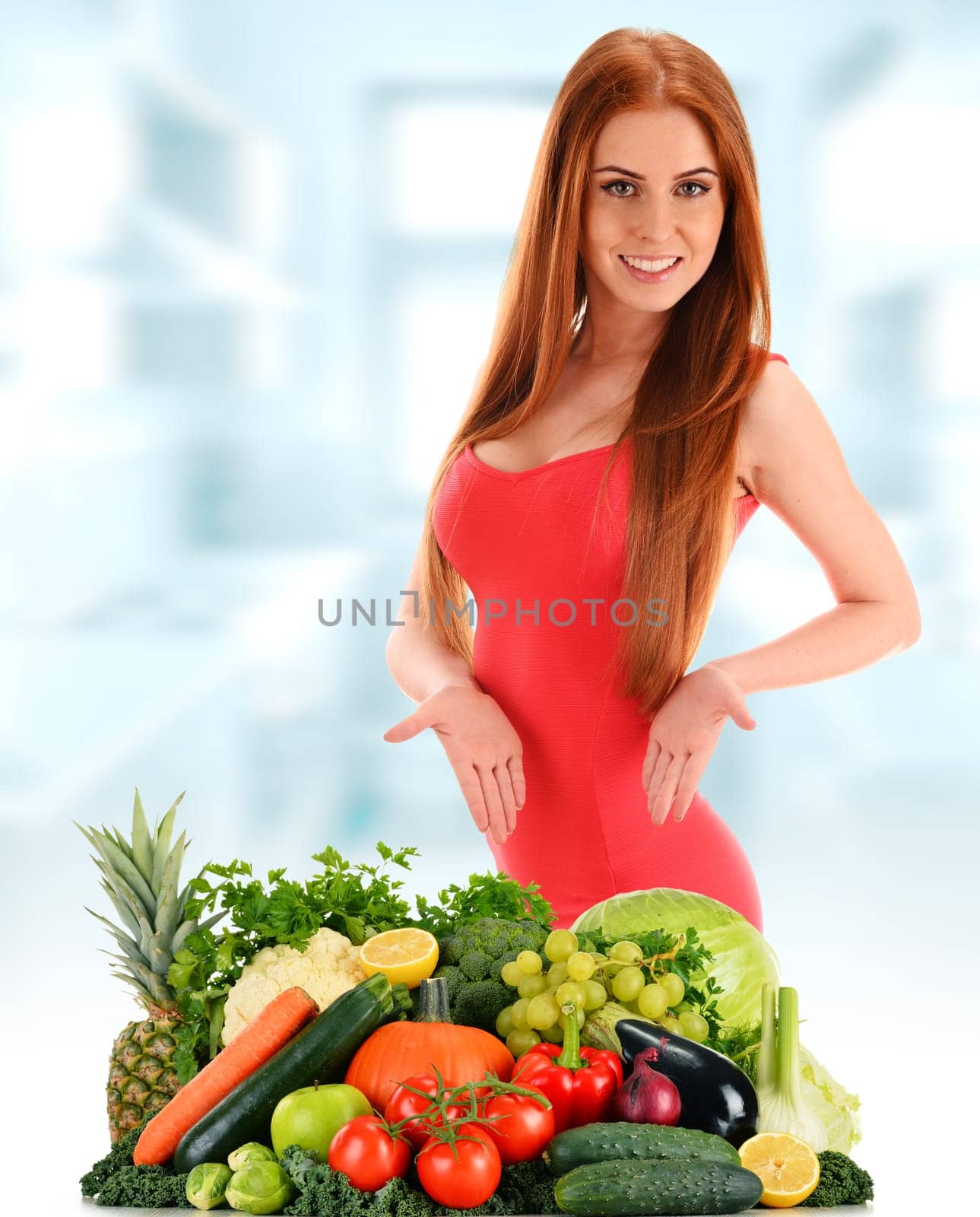 Young woman with variety of organic vegetables and fruits.
