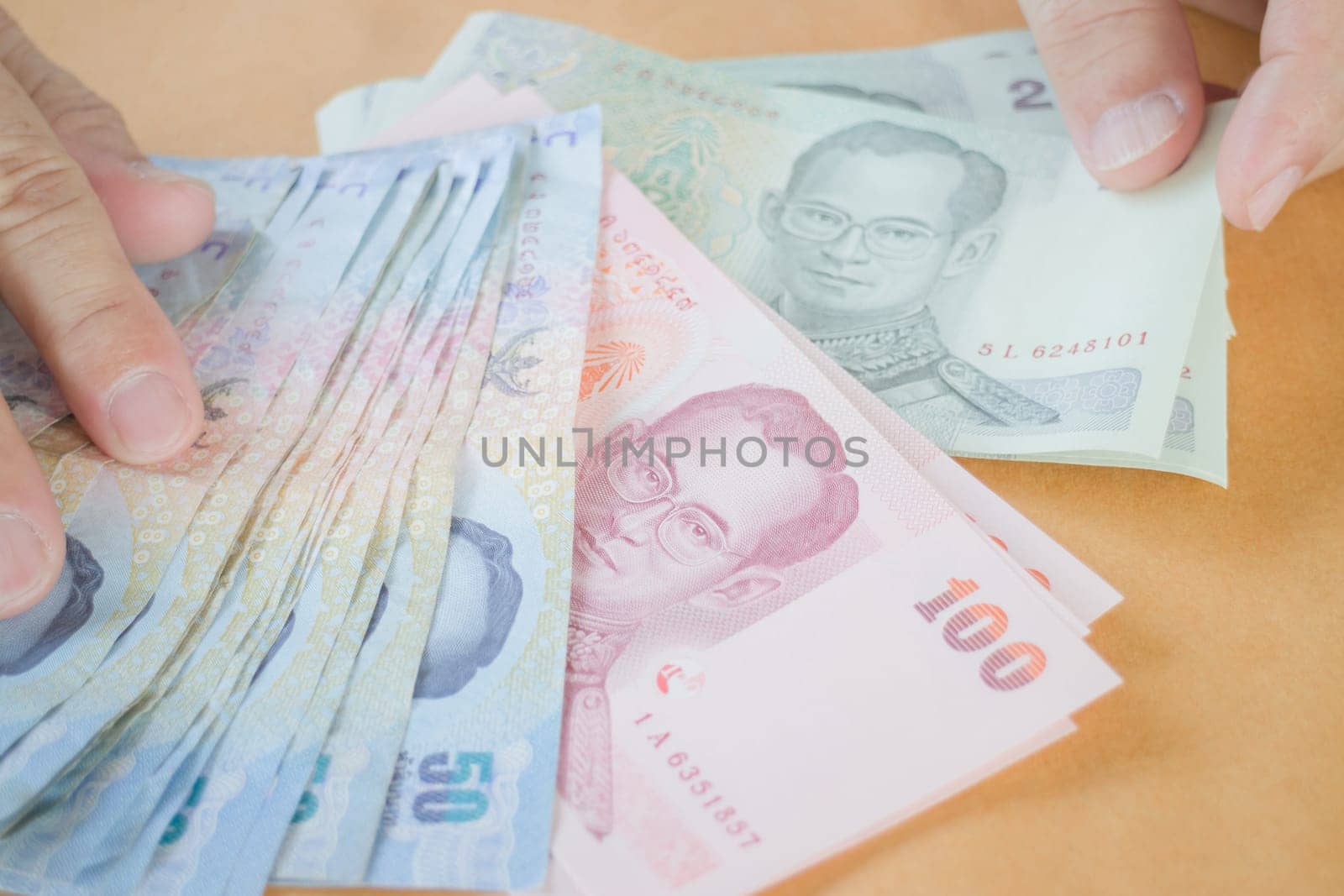 Man hand counting Thai baht banknote, stock photo