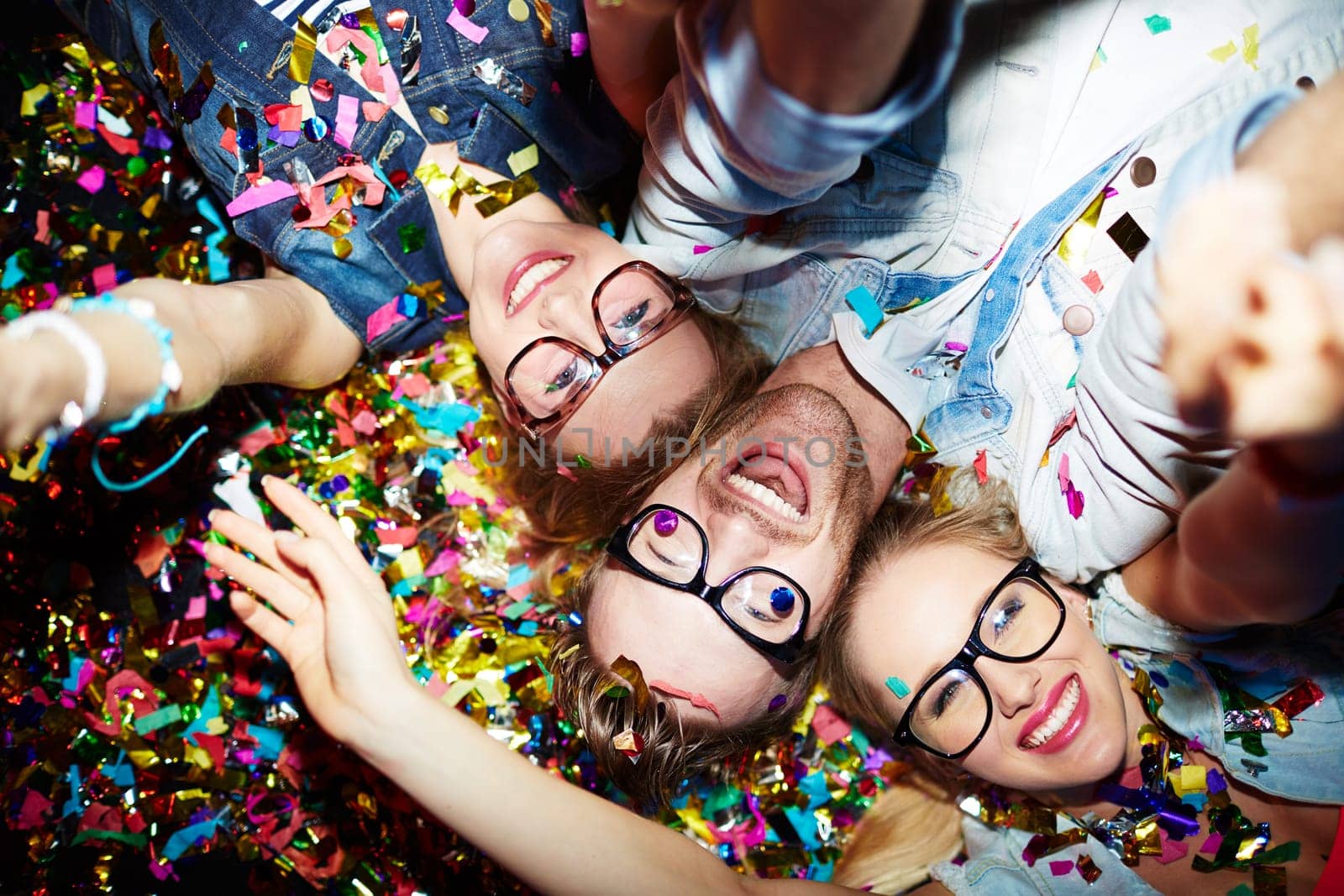 Three smiling friends making selfie while lying on the floor in nightclub