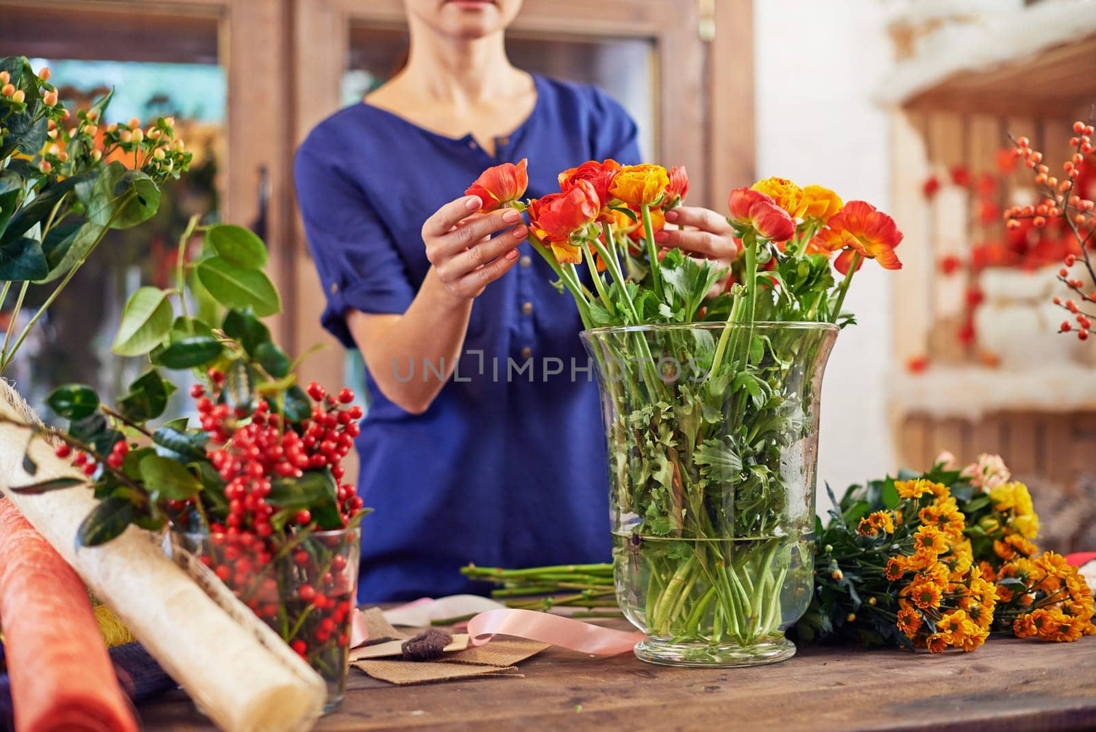 Female florist touching fresh flowers during work in studio