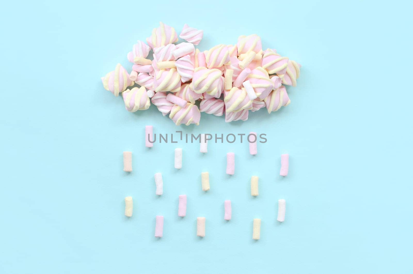 Marshmallow rain cloud on pastel light blue background. Cute metaphorical bad weather concept. Minimal flat lay top view