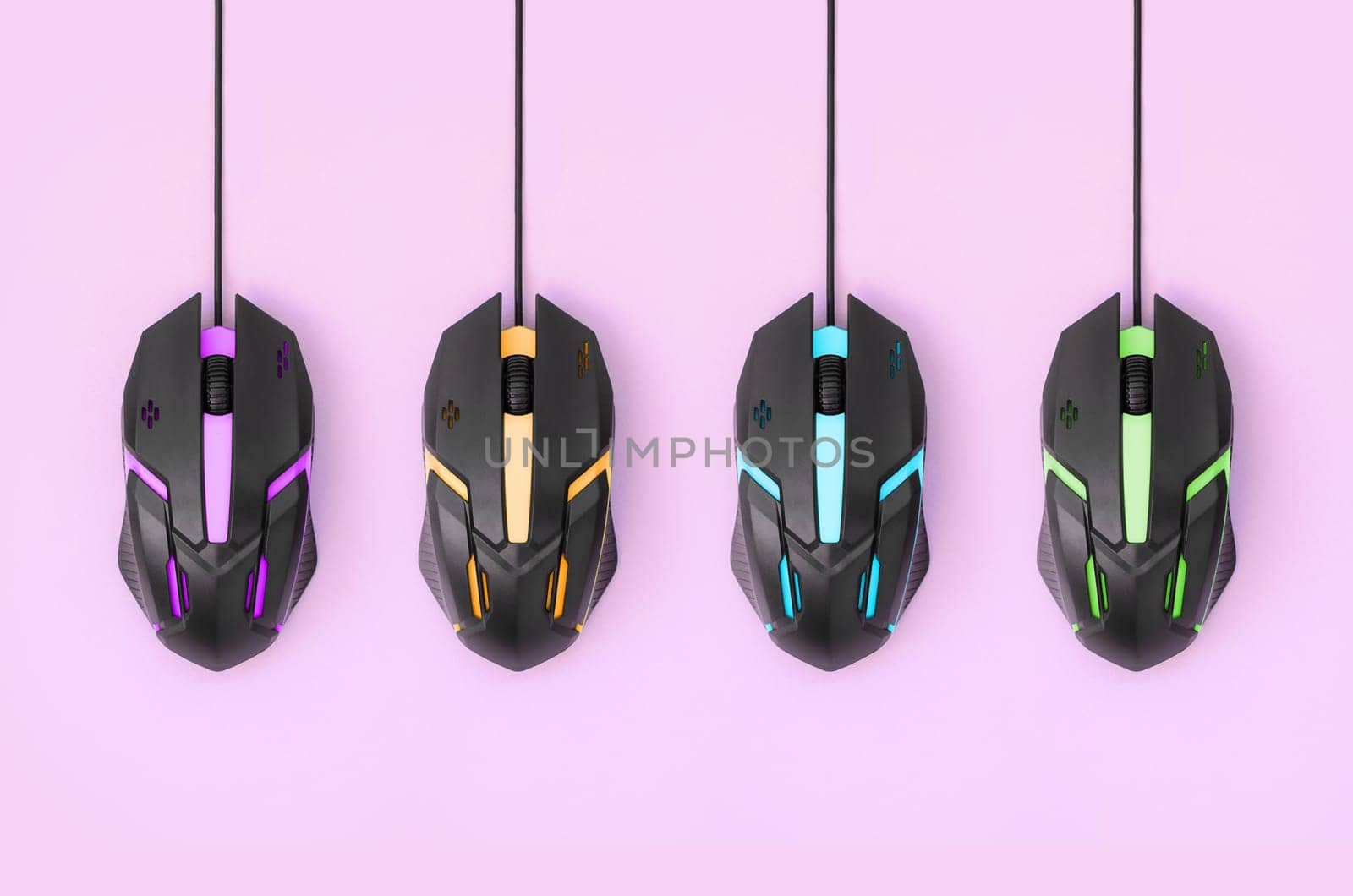 Several computer mice hang on a pastel pink background. The concept of cooperative computer video games, the use of auto-clicker and pay-per-click platforms. Flat lay abstract minimal composition