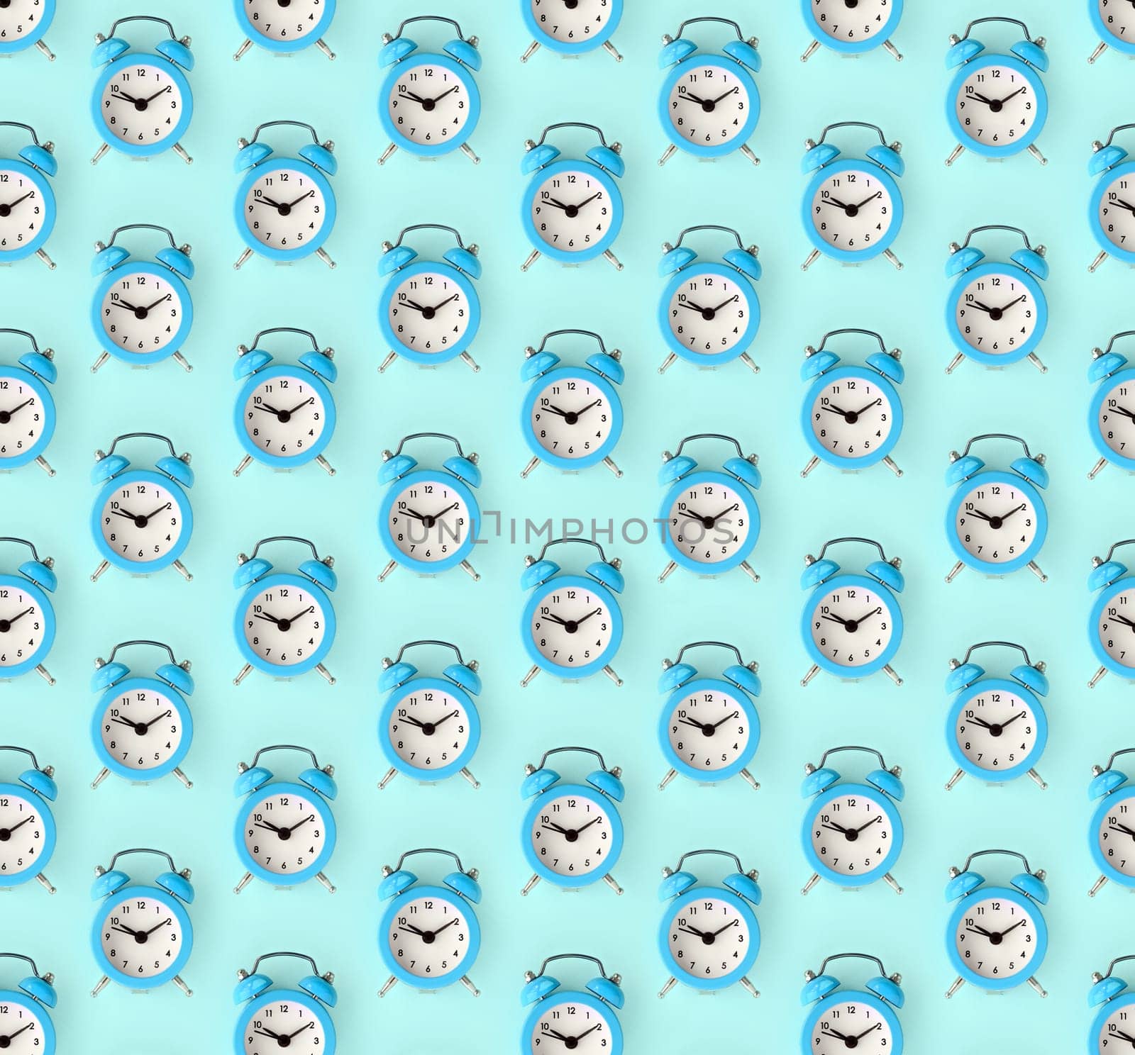 Flat lay retro beautiful new alarm clock on blue color background. Minimal pattern. Top view. Wasting time concept