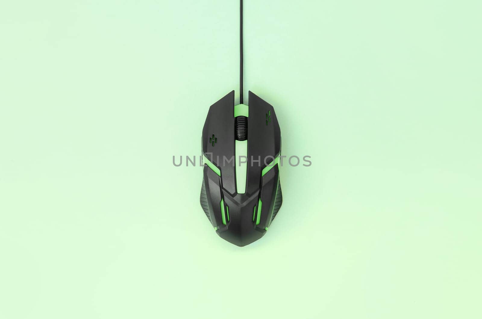 Black gaming optical mouse on a light green background. Device for cybersport and online video games