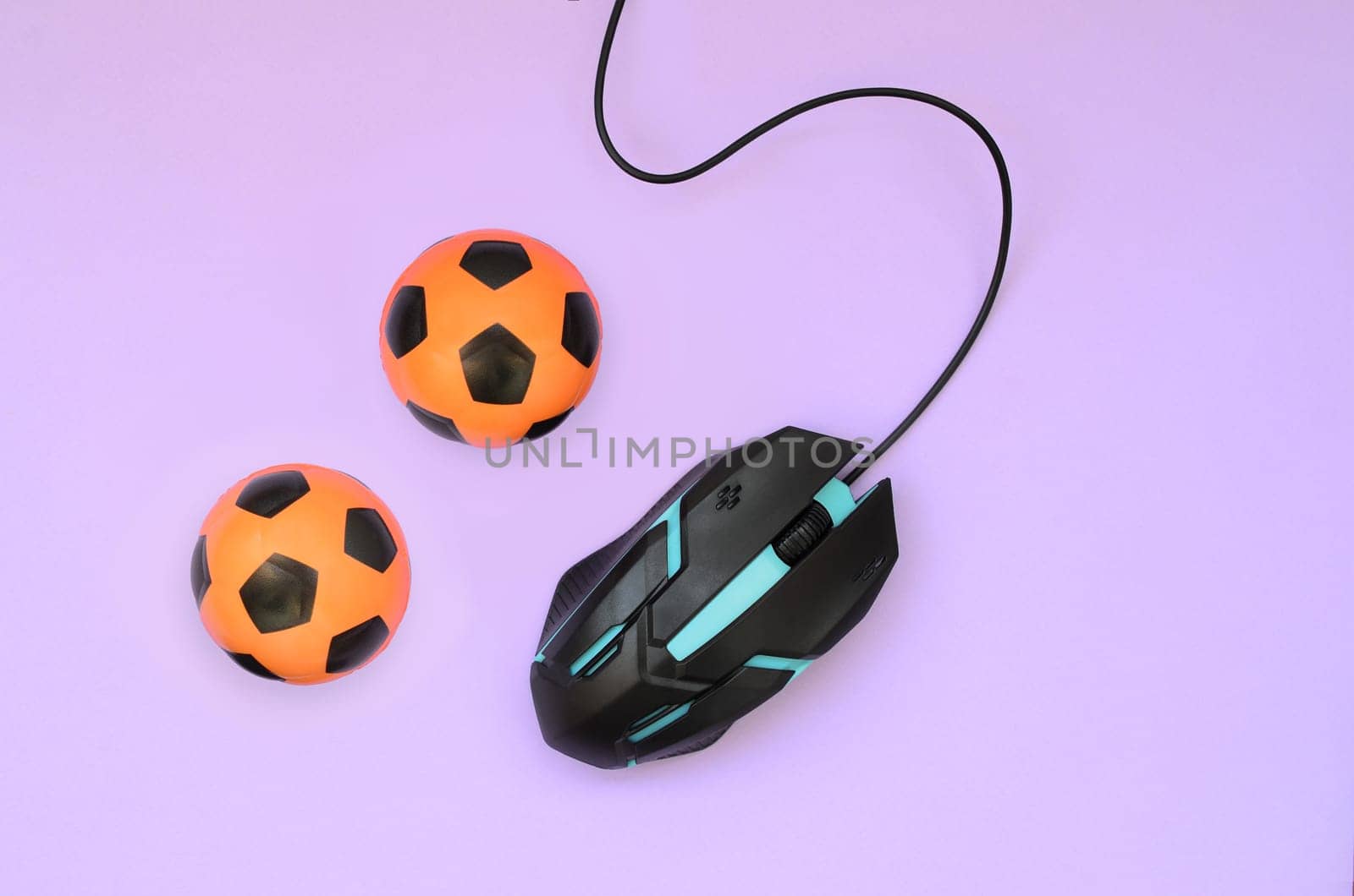 Two soccer balls with computer mouse on violet background. Concept of videogames, eSports, sports betting and online gambling
