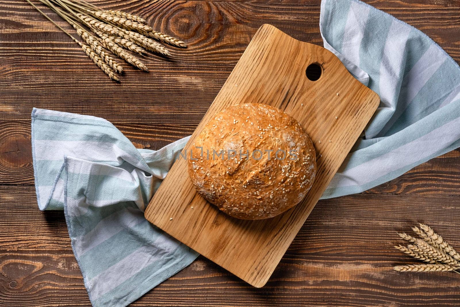 Overhead view of homemade wheat bread on wooden cutting board