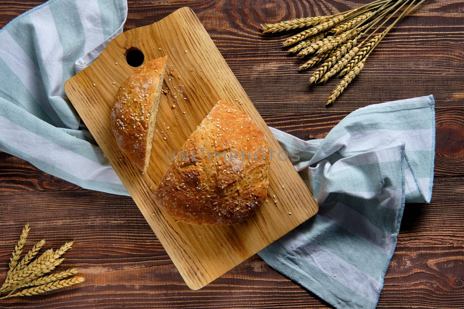Overhead view of homemade wheat bread on wooden cutting board