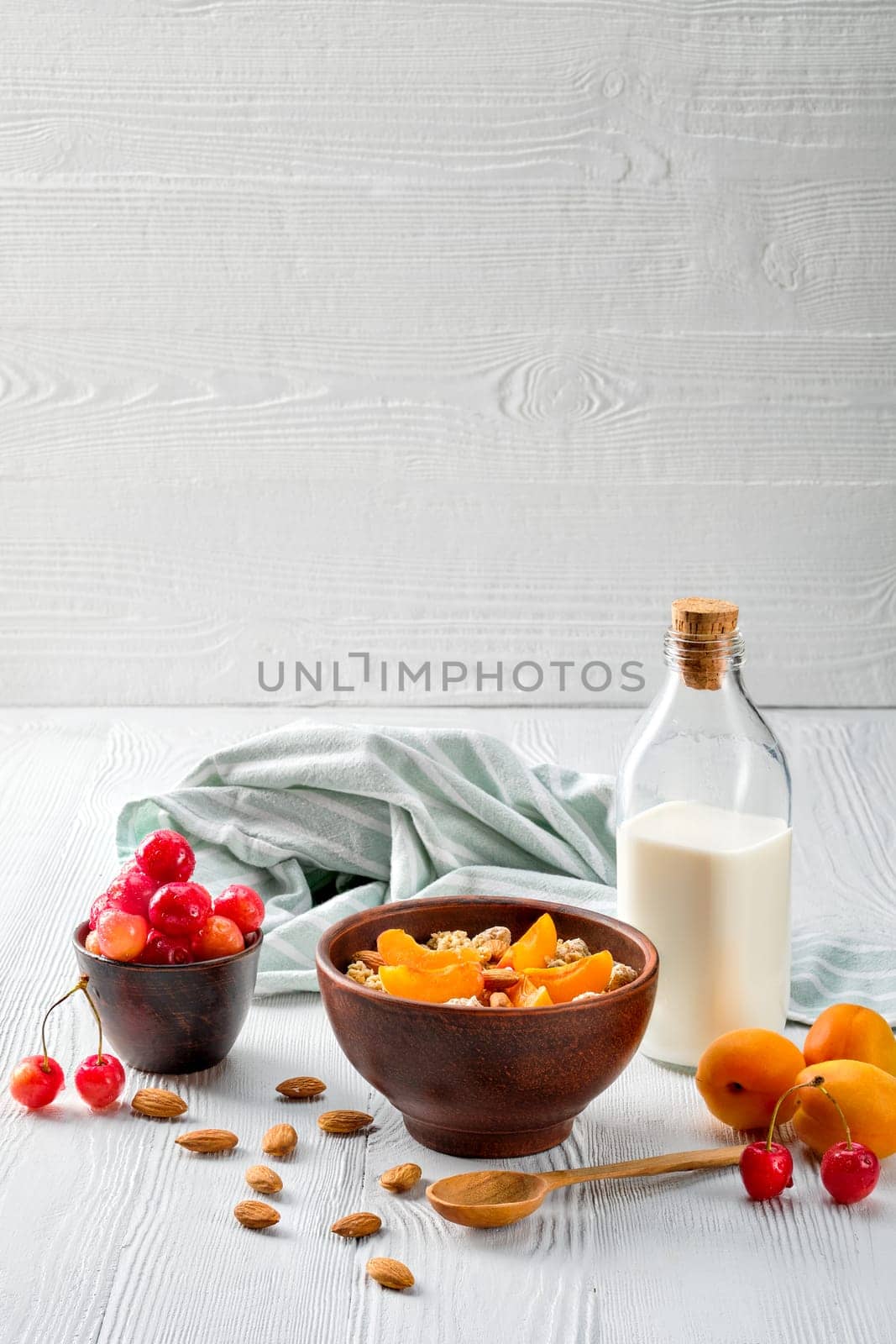 muesli with apricots and almonds on white wooden table