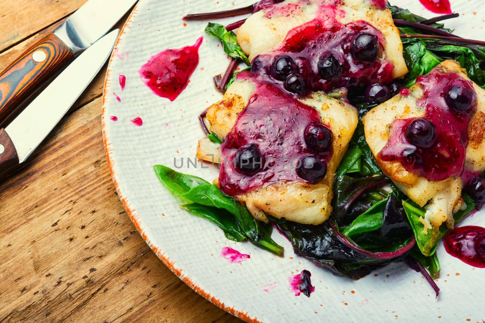 Delicious baked fish with berry sauce. Stewed pangasius with blueberries