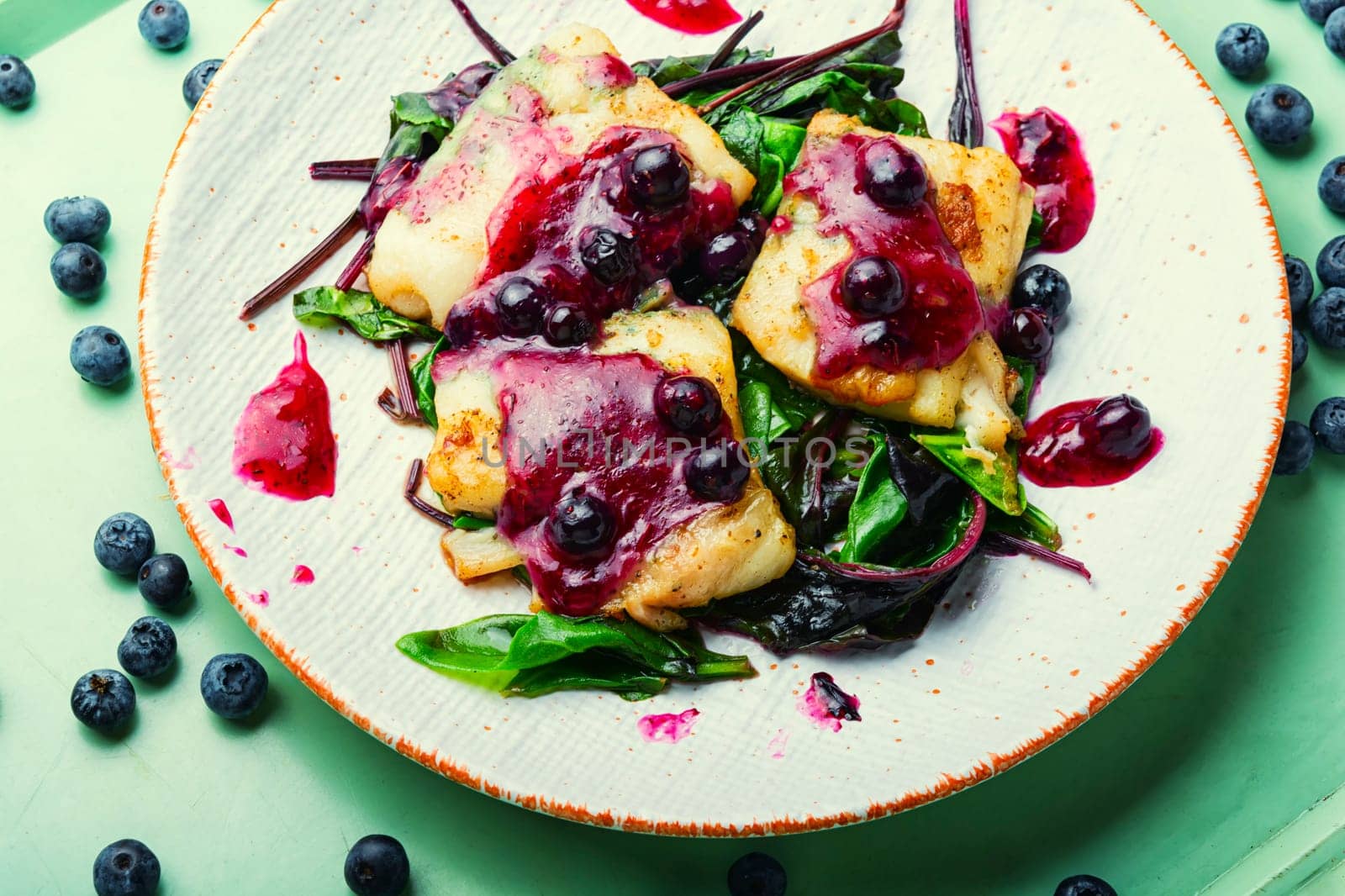 Delicious baked fish with berry sauce. Stewed pangasius with blueberries