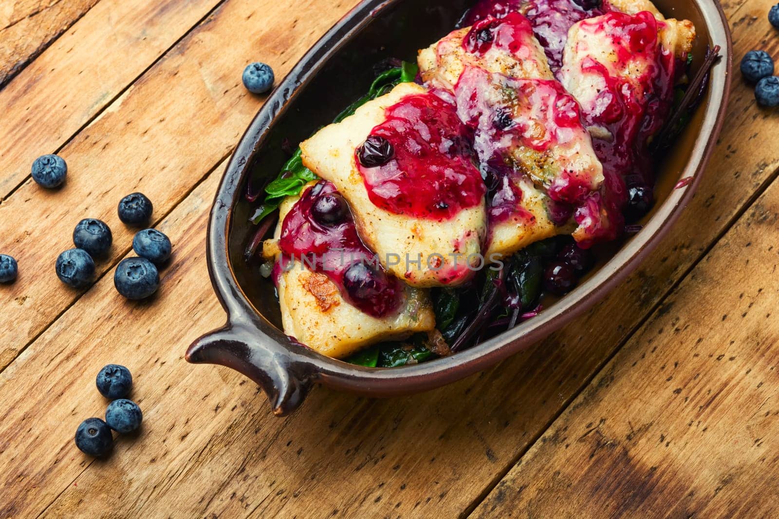 Delicious baked fish with berry sauce. Stewed pangasius with blueberries