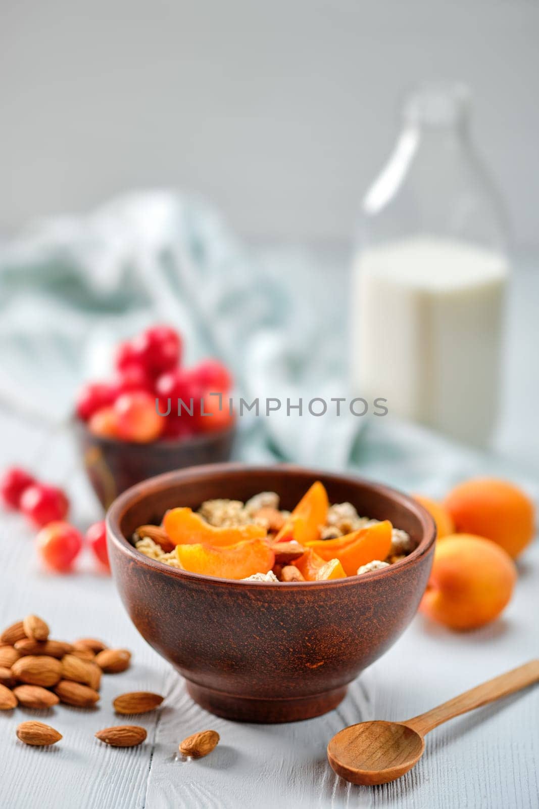 muesli with apricots and almonds on white wooden table