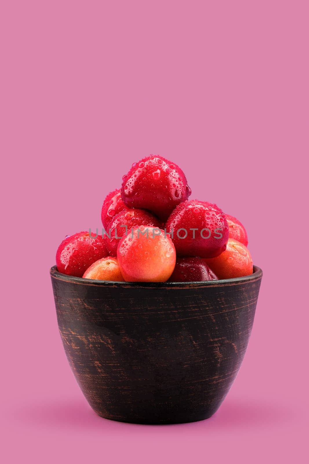 Fresh red cherries in clay bowl