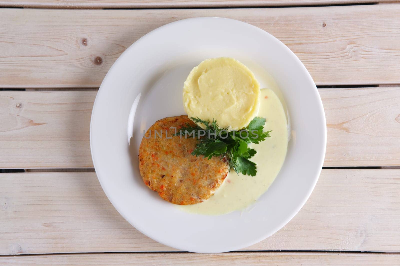 Top view of fish cutlet with mashed potato on wooden table